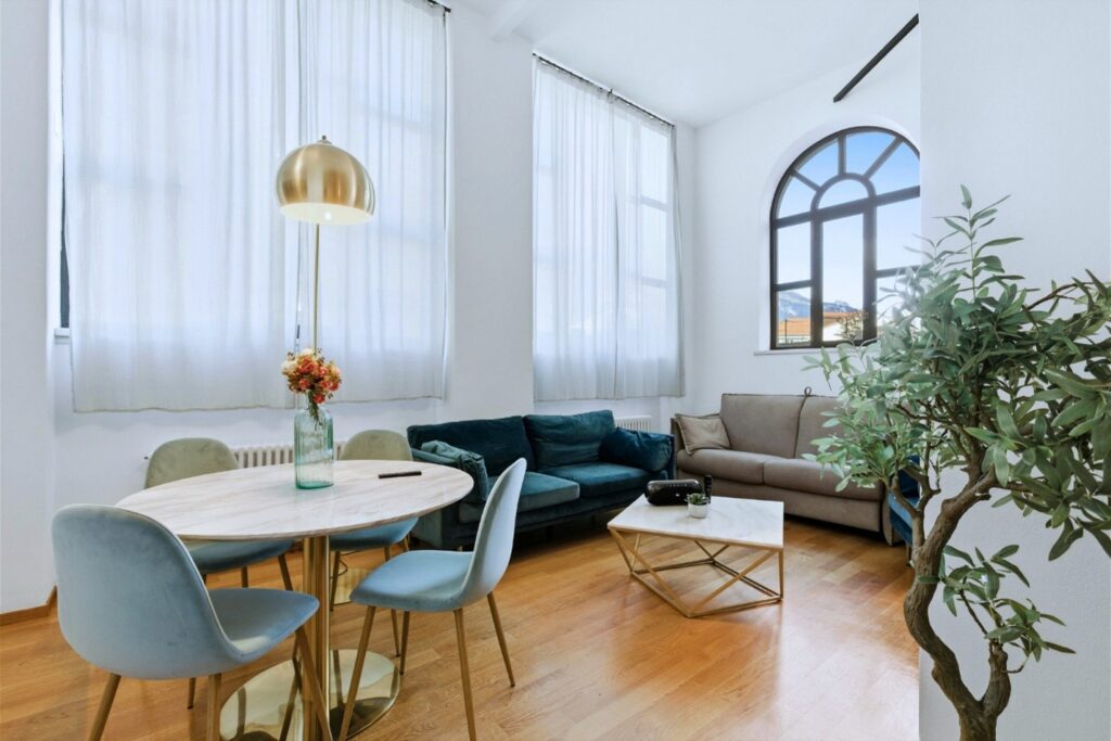 Picture49 Bright living room with tall windows, a dining table, sofas, and a coffee table in a modern open-concept home.
