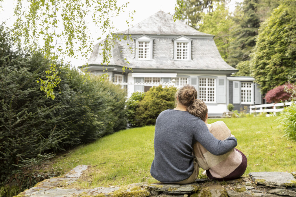Rear view of couple sitting on a wall in garden